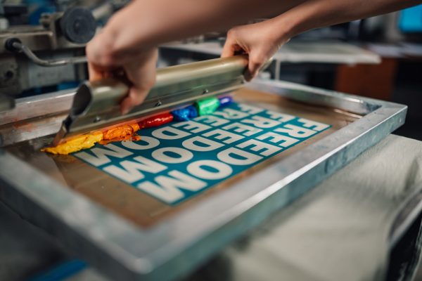 graphic-worker-s-hands-pressing-ink-with-squeegee-2024-04-08-20-43-50-utc