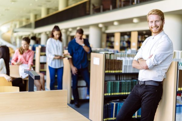 Group of smart young people educating themselves in a library