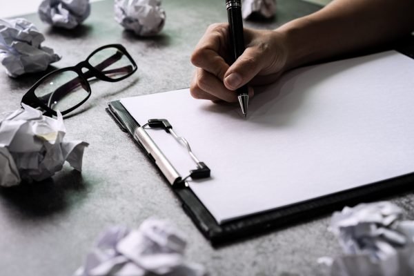 hand-writing-on-file-folder-with-crumpled-paper-ba-2025-03-09-10-37-04-utc