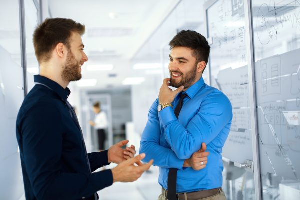 two-businessman-having-a-conversation-in-hallway-2025-03-12-23-06-21-utc